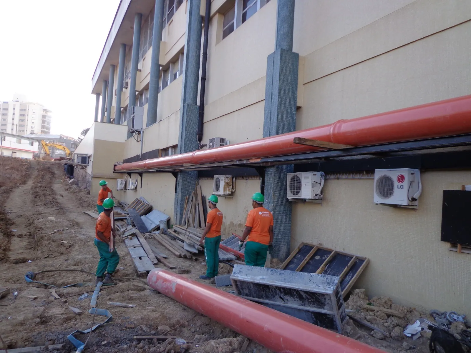 Equipe da Tubotech uniformizada instalando rede pluvial na fachada de um prédio