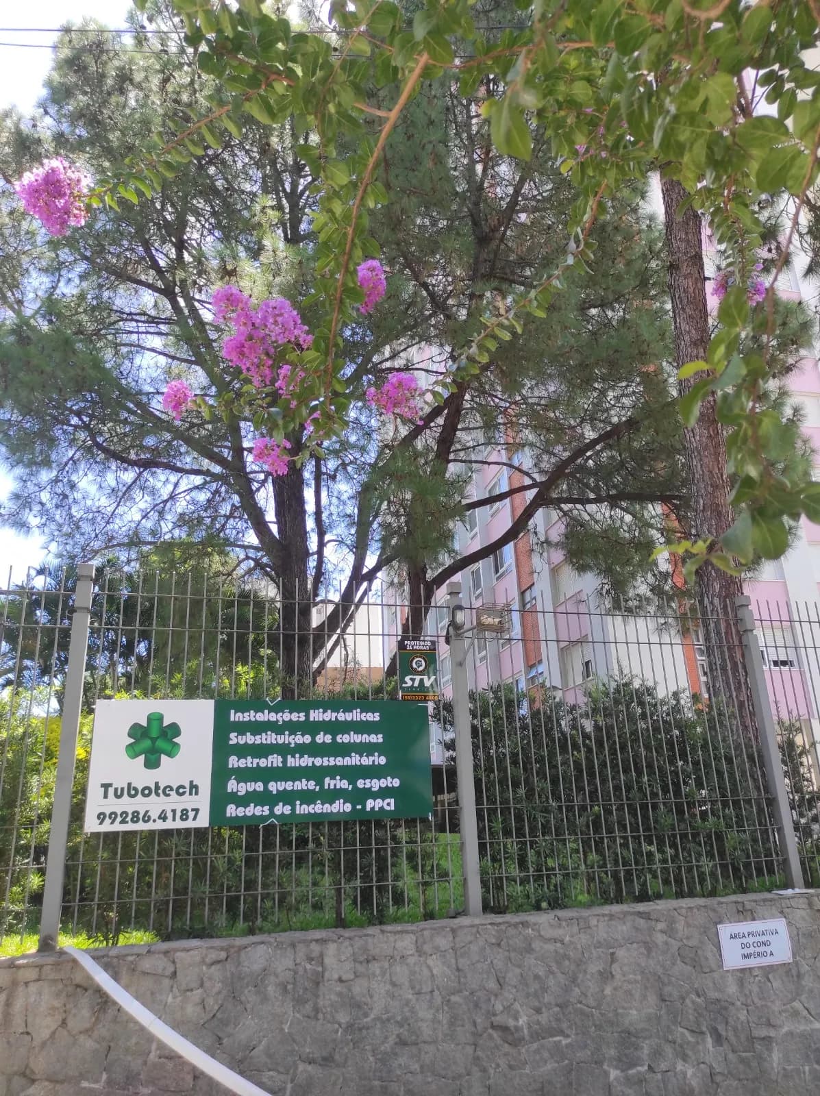 Placa da Tubotech instalada em obra de condomínio, com contato e serviços prestados