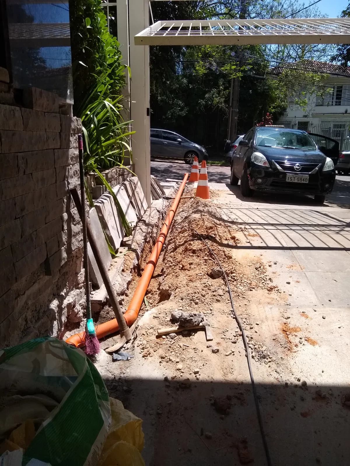 Instalação de rede de esgoto em vala aberta na calçada